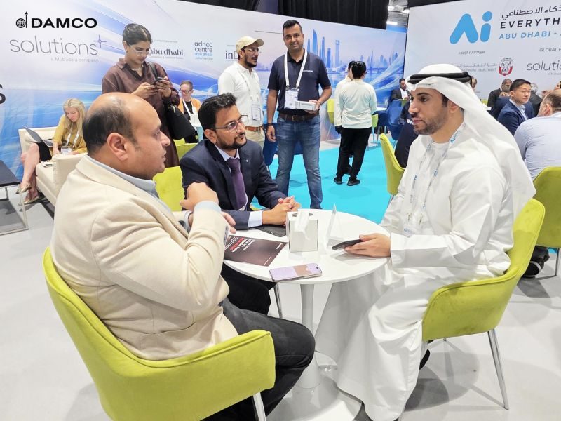 A Damco strategist in conversation with visitors at a Damco booth