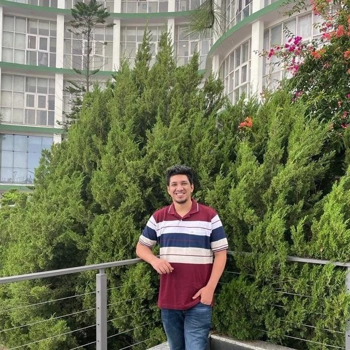 Antariksh Gupta standing by a railing among trees