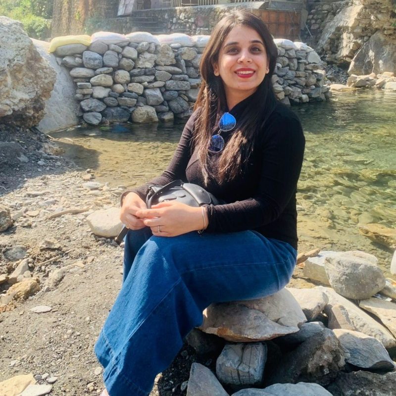 Priyanka Narang sitting by a stream